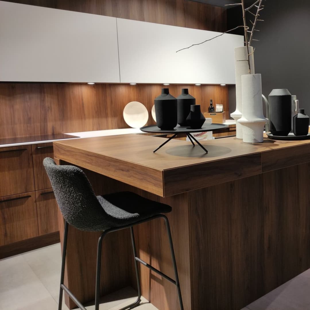 Cuisine moderne haut de gamme en bois noyer et façades blanches avec ilot central au style chaleureux et contemporain
