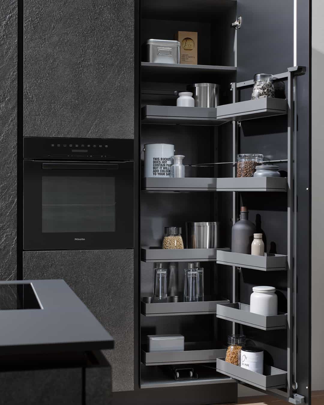 Colonne de cuisine noire avec garde-manger à paniers extractibles sur la porte et étagères intérieures. Optimisation de rangement IDÉO Cuisines