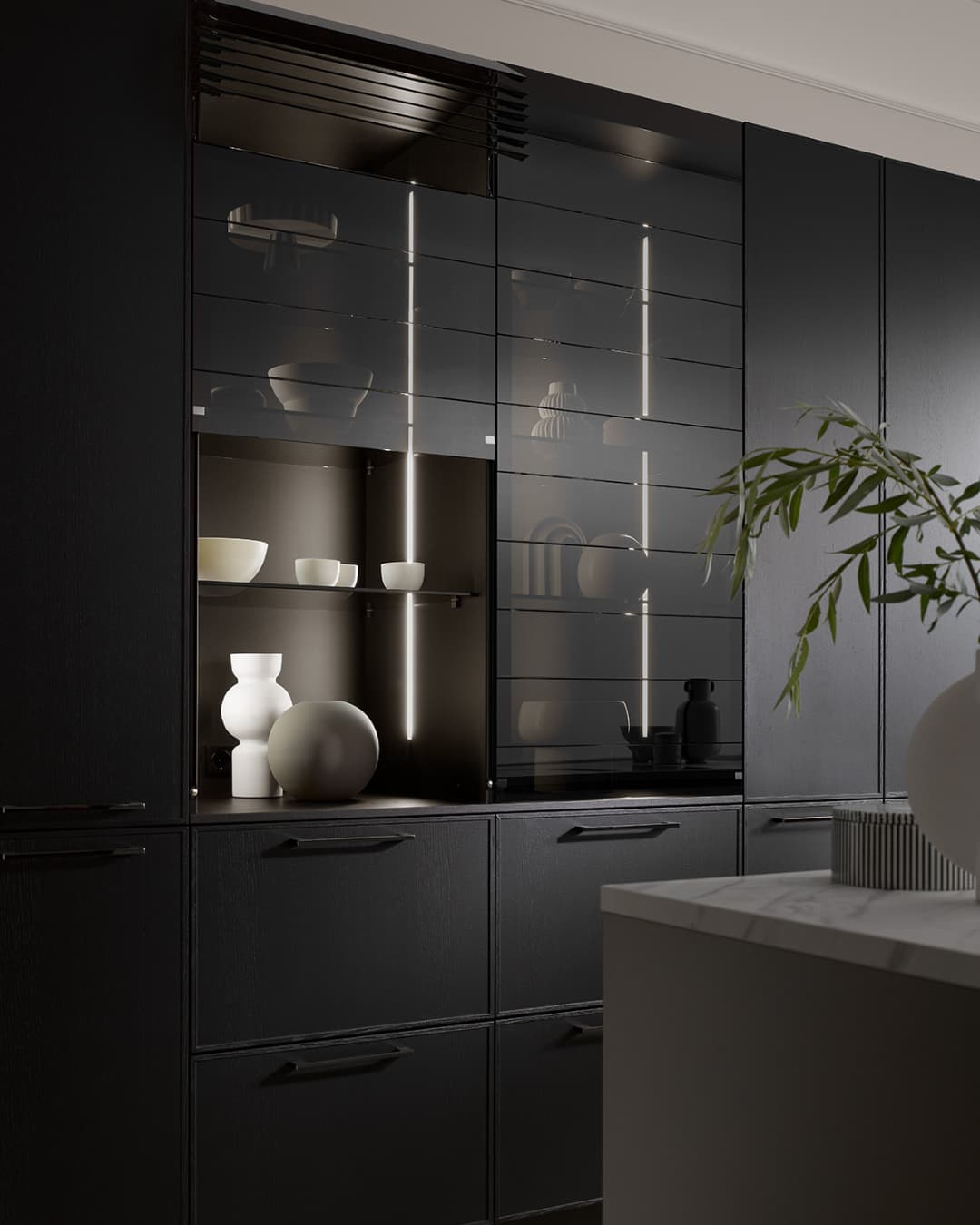 Cuisine moderne noire avec portes à cadre fin type slim shaker et vitrines éclairées, mélange d’élégance contemporaine et de discrétion.