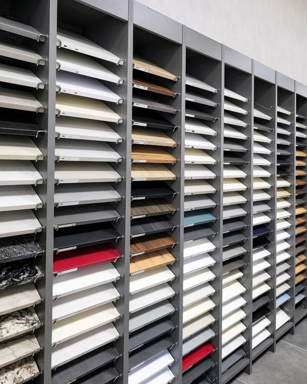 Nuancier d’échantillons de façades et plans de travail en showroom IDÉO Cuisines : finitions bois, pierre et couleurs pour cuisine sur mesure.