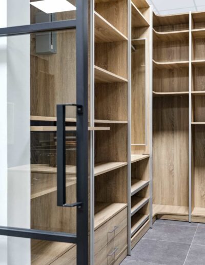 Dressing sur mesure en bois avec portes vitrées dans le showroom d’aménagements IDEO à Bastogne