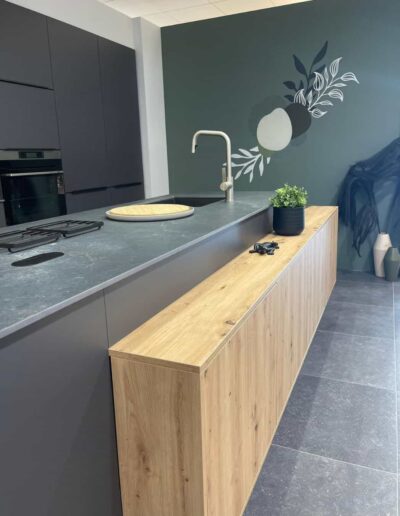 Cuisine équipée design avec îlot noir, plan de travail en pierre dans le showroom de cuisines IDEO à Libramont