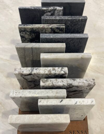 Échantillons de plans de travail en granit et quartz présentés dans le showroom de cuisines IDEO à Libramont