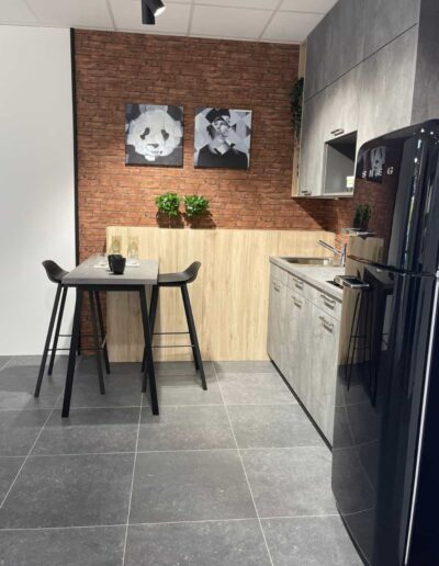 Petite cuisine équipée au style industriel, meubles gris et frigo vintage noir à Libramont