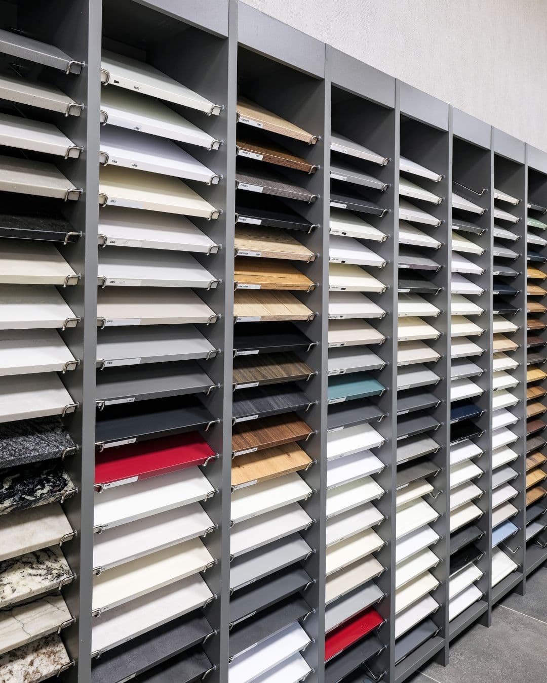 Échantillons de couleurs, bois et matériaux présentés dans le showroom IDEO pour personnaliser une cuisine ou un aménagement intérieur.